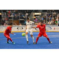 Florida Tropics defender Lucas Montalres dribbles between two Kansas City Comets